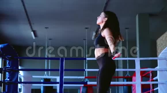 贴身迷人的可爱的苗条的深褐色皮肤的女运动员在健身房里跳绳子训练拳击视频的预览图
