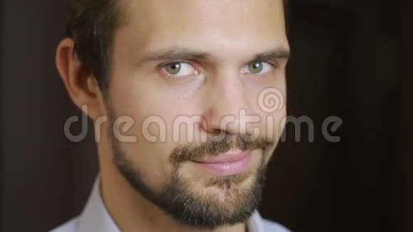 英俊的时尚模特男子肖像与绿色的眼睛和微笑接近胡须视频的预览图