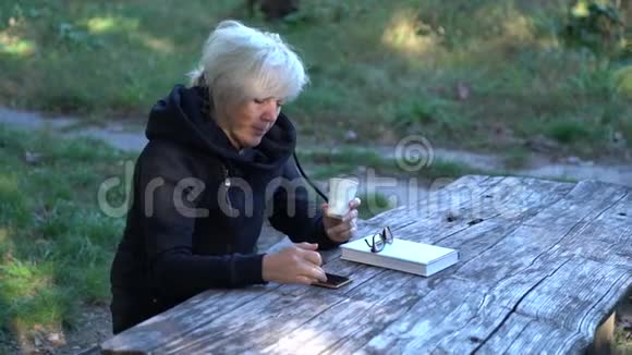 坐在公园里喝咖啡的女人视频的预览图