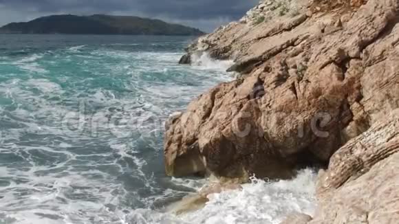 纯净的蓝色水域海洋海岸波浪打破和飞溅冒险海上海岸冲浪岩石录像夏季视频的预览图