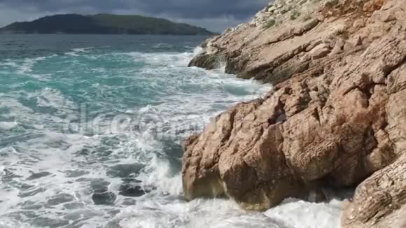 纯净的蓝色水域海洋海岸波浪打破和飞溅冒险海上海岸冲浪岩石录像夏季视频的预览图