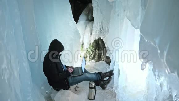 黑客攻击服务器在冰洞里用笔记本电脑编程围绕着神秘的冰窟男人把自己藏在视频的预览图