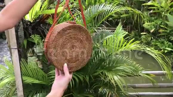 女人的手与Stylich环保藤袋在热带背景巴厘岛视频的预览图