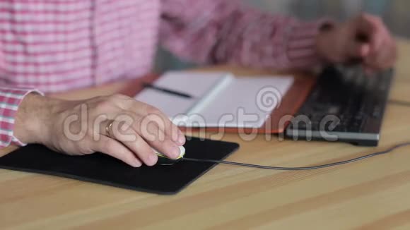 在桌旁用电脑鼠标工作的人视频的预览图