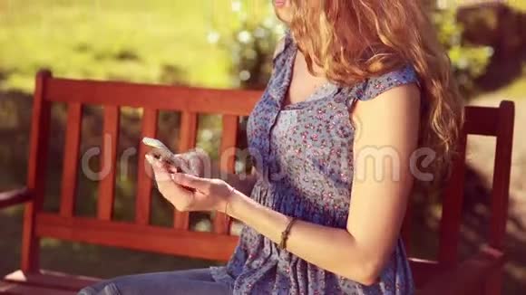 在公园里用手机高质量的4k格式金发美女视频的预览图