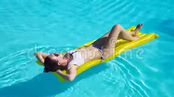 女人在绿松石水充气床垫上放松视频的预览图
