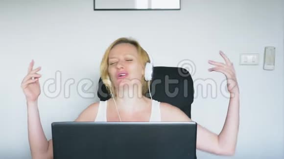 一个女人用她的笔记本电脑坐在桌子旁笑着说话人类的情感网瘾视频的预览图