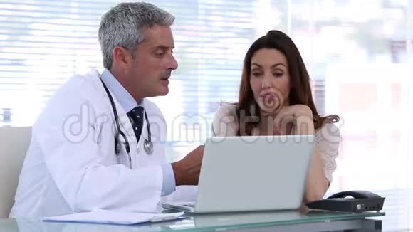 医生用笔记本电脑解释病人的疾病视频的预览图