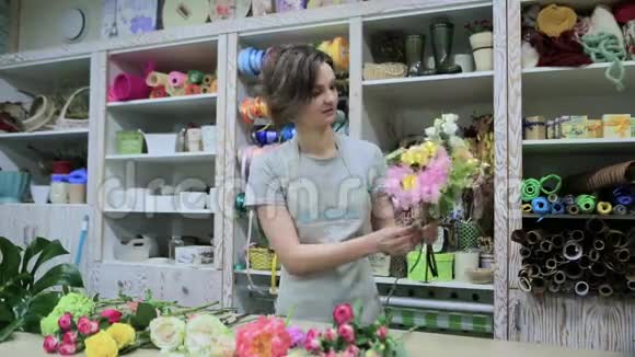 年轻女子花店里聚集了一束花视频的预览图