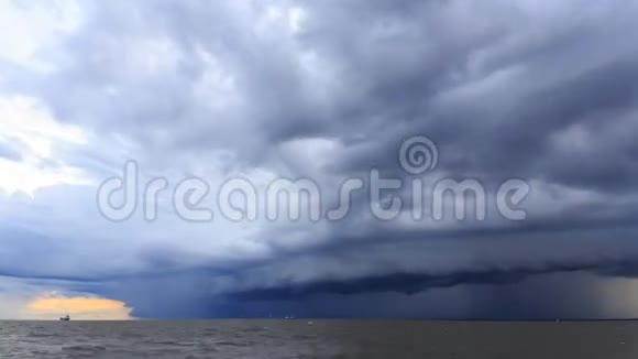 在海上河口日落前雨云在天空中蔓延货船驶过视频的预览图