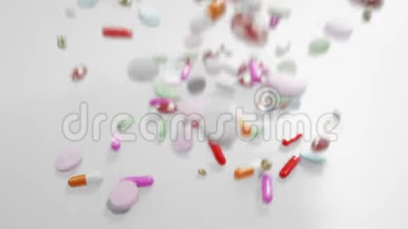 各种彩色药丸用移动照相机落在白色表面视频的预览图