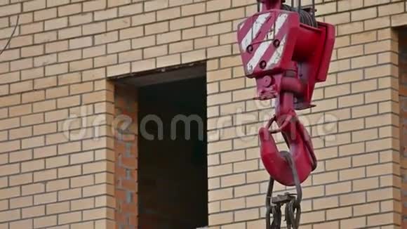 吊钩起重机在砖房建筑后面随风摆动视频的预览图