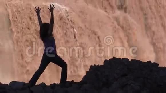从大瀑布练习瑜伽的女人身上放大视频的预览图