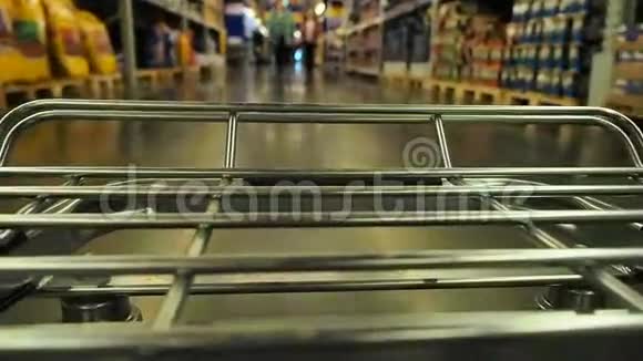 大型超市的购物车在模糊的货架之间移动视频的预览图