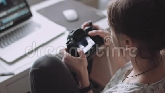 女摄影师在她的相机上看照片视频的预览图