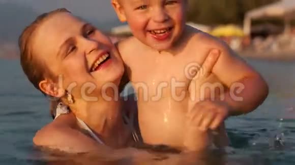 快乐的母亲把儿子扔到海里视频的预览图