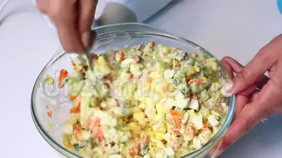 带有蔬菜和蛋黄酱的俄罗斯肉沙拉一个女人把蛋黄酱和沙拉的配料混合在一起视频的预览图