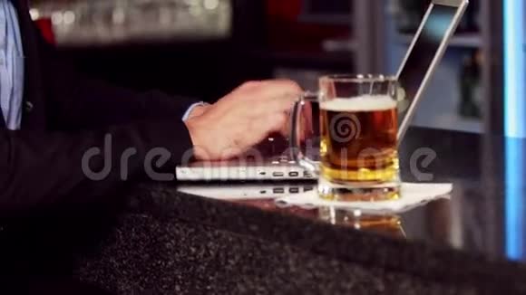 一个商人在他的笔记本电脑上喝酒视频的预览图