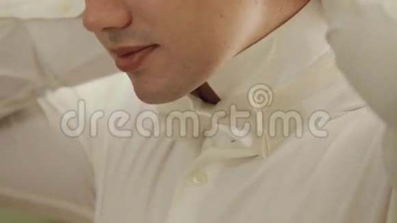 新郎为婚礼穿衣服戴上蝴蝶结视频的预览图