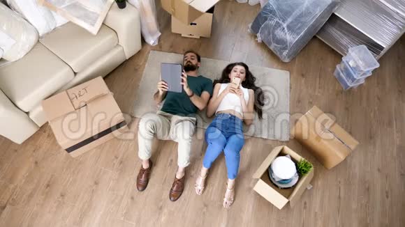 顶景夫妇躺在新公寓的地板上视频的预览图