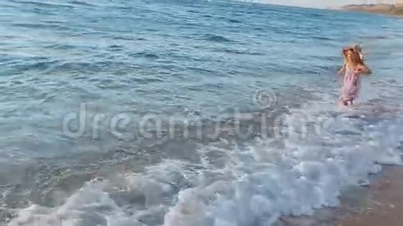 一个快乐的小女孩在海边跑来跑去视频的预览图