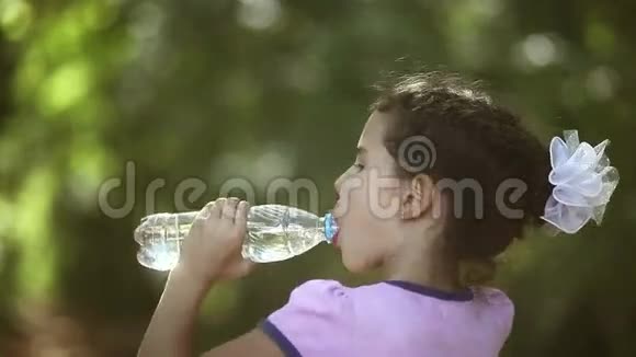 十几岁的女孩从塑料瓶里喝水视频的预览图