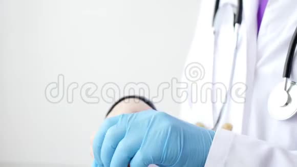 医生戴上蓝色乳胶手套视频的预览图