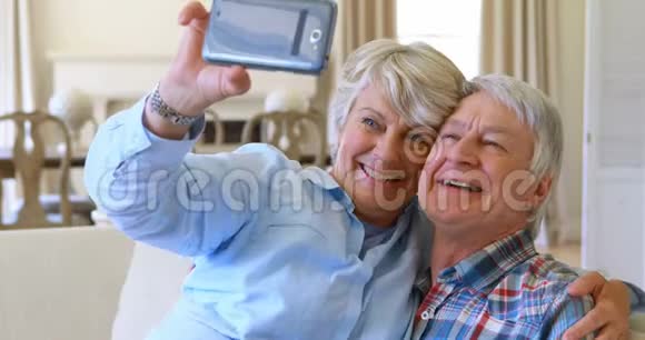 年长夫妇在客厅用手机自拍视频的预览图