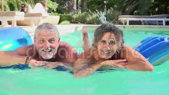 在游泳池的空气中放松的成熟情侣视频的预览图