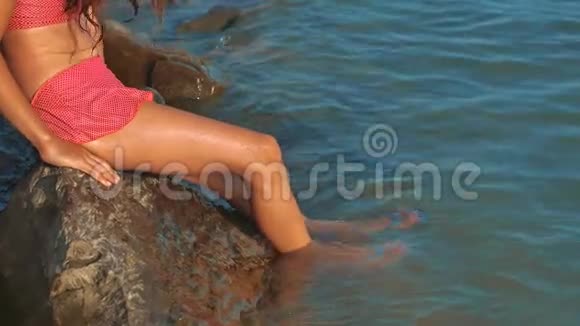 小女孩用石头生活方式和石头在海里洗澡少女的女儿在海浪中游泳视频的预览图