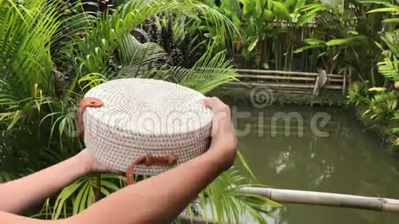 女人的手与Stylich环保藤袋在热带背景巴厘岛视频的预览图