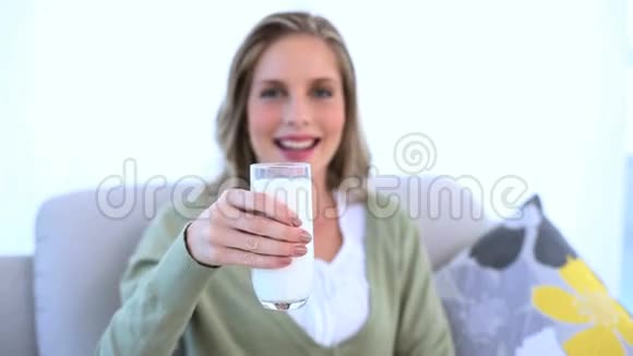 女人把她的一杯牛奶拿给镜头看视频的预览图