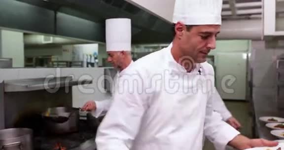 微笑英俊的厨师展示两道菜相机视频的预览图