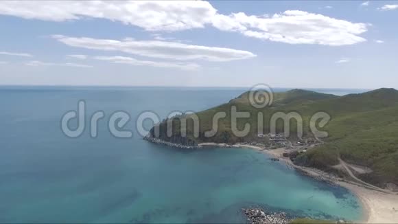 阳光灿烂的热带海洋海岸的空中拍摄热带的蓝色海洋绿色的树木山峦悬崖蓝天视频的预览图
