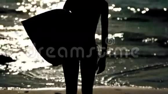 一个漂亮女人拿着冲浪板的剪影视频的预览图