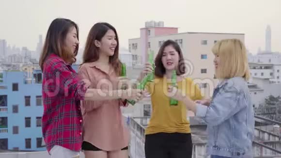 一群年轻的亚洲女性在日落都市派对上随着DJ演奏的音乐翩翩起舞举起双臂视频的预览图