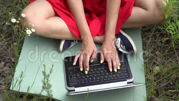 年轻时髦的女人打字键盘女孩在外面用笔记本电脑视频的预览图