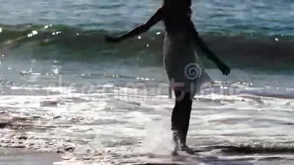 女人在波浪中旋转的剪影视频的预览图