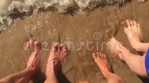 男孩女孩和男人家庭水腿在海洋慢动作视频强浪沙海休息家庭视频的预览图