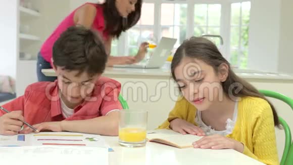 孩子们在妈妈使用笔记本电脑时做作业视频的预览图