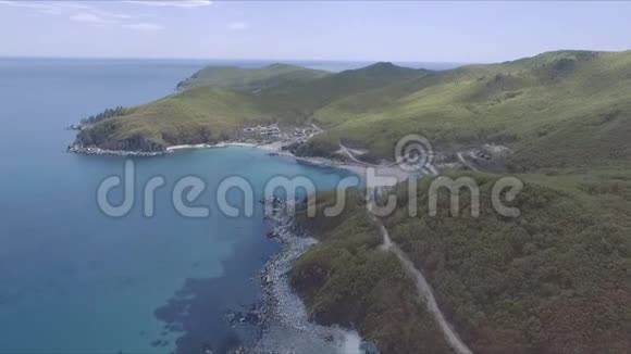 阳光灿烂的热带海洋海岸的空中拍摄热带的蓝色海洋绿色的树木山峦悬崖蓝天视频的预览图