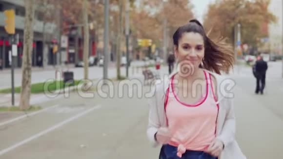 女人在城市的街道上奔跑背景是建筑物视频的预览图