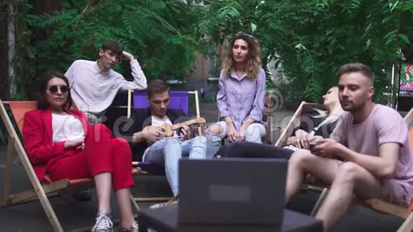 一群年轻人在夏季咖啡馆休息视频的预览图
