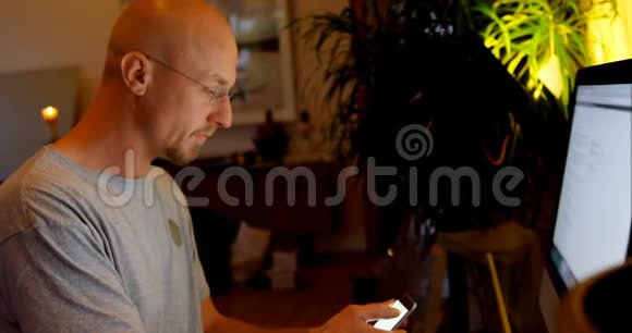 男子使用手机和台式电脑4k视频的预览图