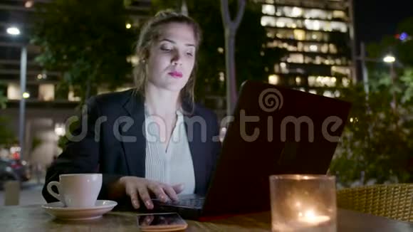 商务女性晚上坐在咖啡馆里在笔记本电脑上工作打电话视频的预览图
