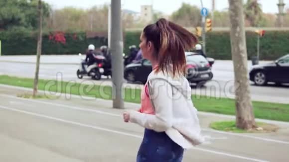 女人在城市的街道上奔跑背景是建筑物视频的预览图