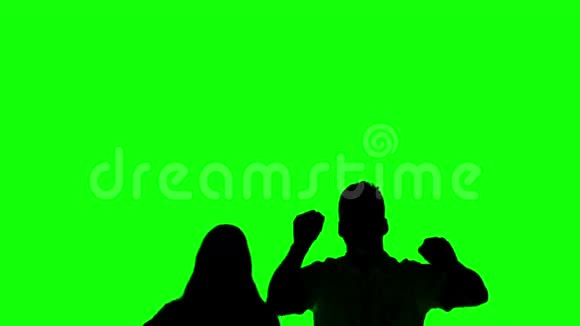 一对夫妇在绿色屏幕上跳跃和举起手臂的剪影视频的预览图