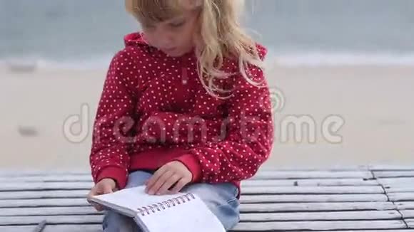 小女孩在海里做梦翻着笔记本视频的预览图