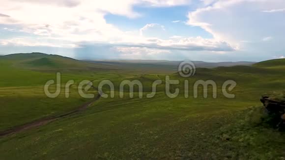 在喀喀西亚共和国风暴来临前从空中俯瞰一望无际的田野山丘干草堆和天空视频的预览图