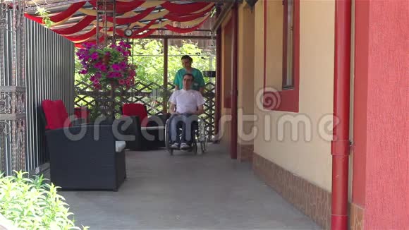 护士与坐轮椅的男性病人同行视频的预览图